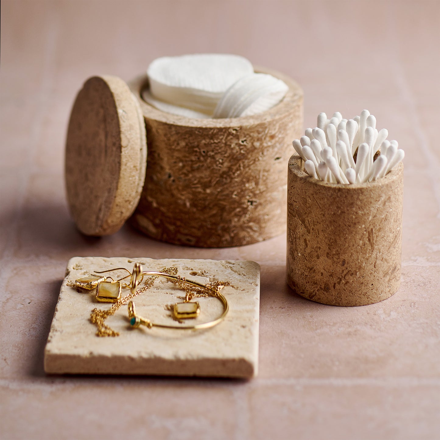 Travertin-Behälter Arinna aus 100 % Travertin dekorativ mit weiteren Badaccessoires arrangiert